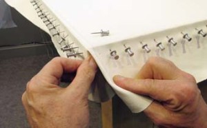 9. After overall stretching / pinning, corner fabric is folded neatly and tucked beneath.