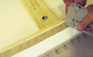 12. Stapling through a woven band cushions the canvas and facilitates future staple removal.
