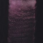 QoR Interference Red watercolor lightfast test result photograph of a 25 water to 1 paint dilution on cold pressed black watercolor paper.